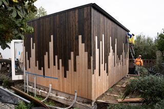 Volunteer crew from Lewis joined forces with Sawhorse Revolution staff to install cedar tongue-and-groove siding at Cherry Street Farm