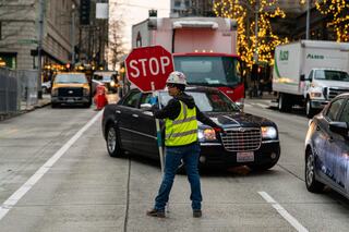 Women construction worker standing on the street with STOP sign at the construction site