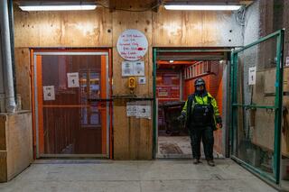 Women construction worker standing in front of the construction elevator