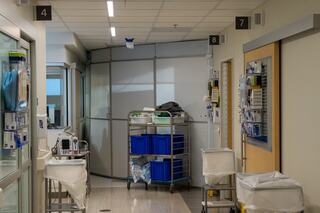 Construction is taking place behind modular walls next to patient rooms.